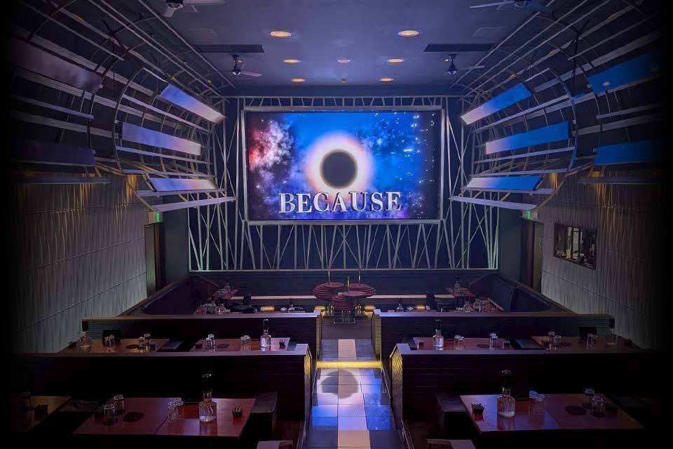 BECAUSE 店内。正面の大型スクリーンと、天井から開くトラスの庇